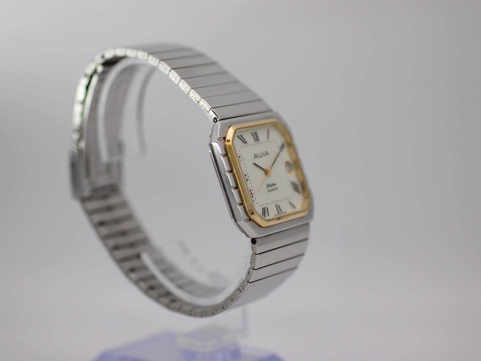 Angled side view of the AVIA Flatline watch on a display stand, highlighting the stainless steel bracelet and case shape.