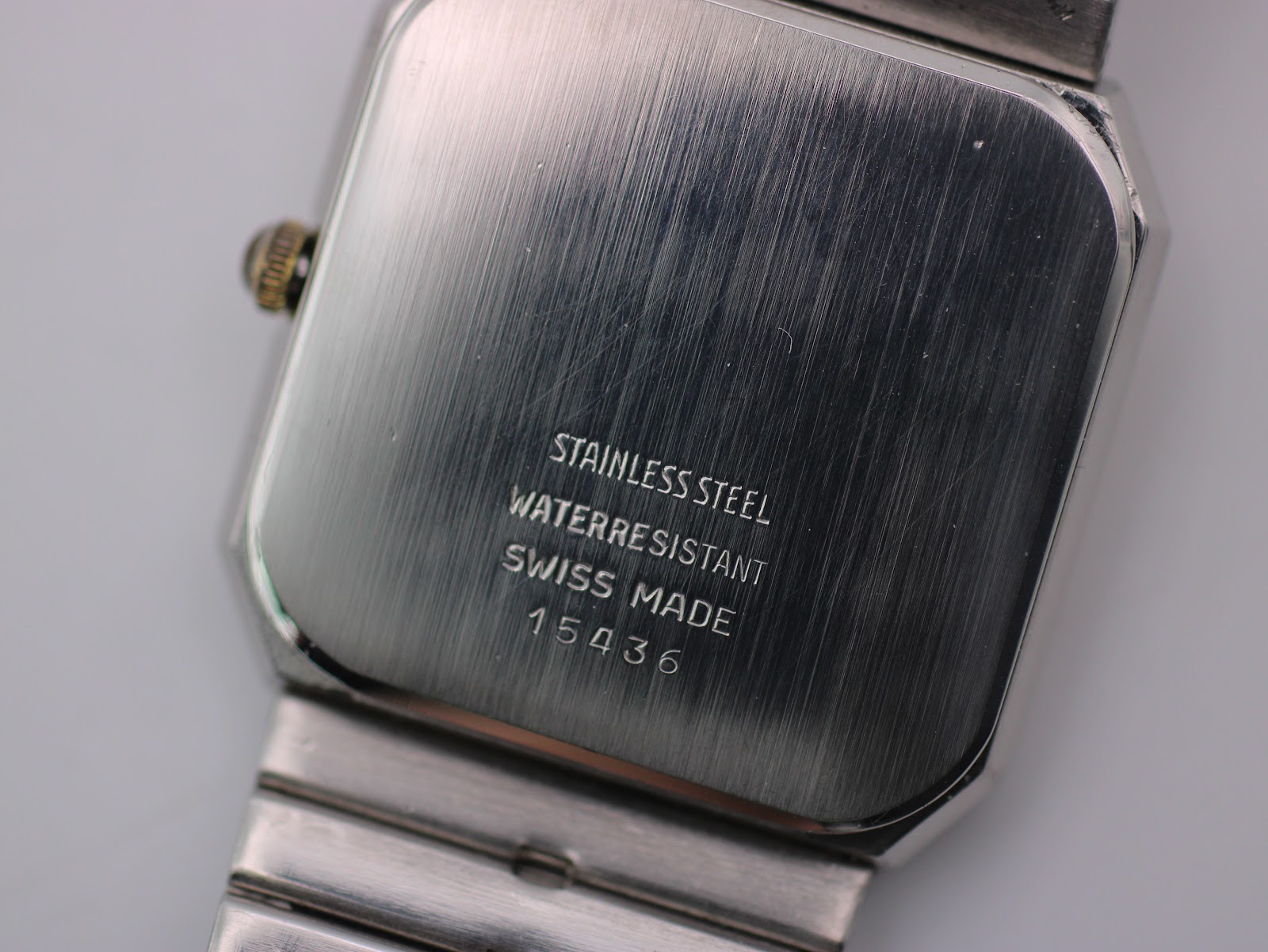 Close-up of the brushed stainless steel case back with "STAINLESS STEEL WATERRESISTANT SWISS MADE 15436" engraving.