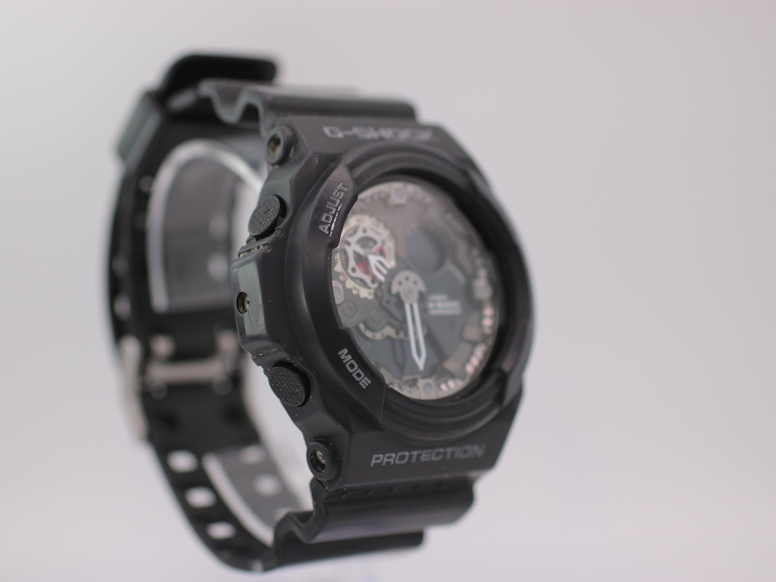 Three-quarter view of black G-SHOCK GA-300 watch from the left, showing side buttons and 'MODE' label on the bezel.