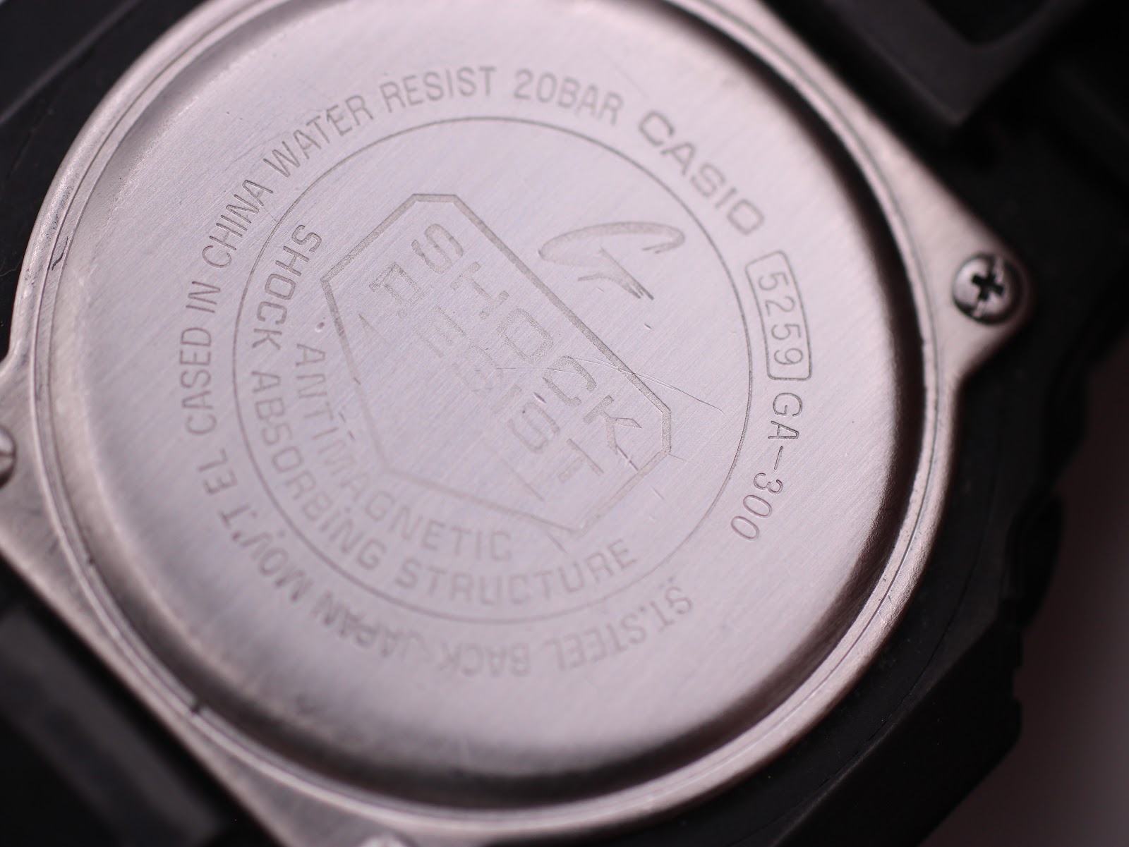 Close-up of the stainless steel case back of the G-SHOCK GA-300, showing model number 5259 GA-300, water resistance 20BAR, and shock resist engraving.