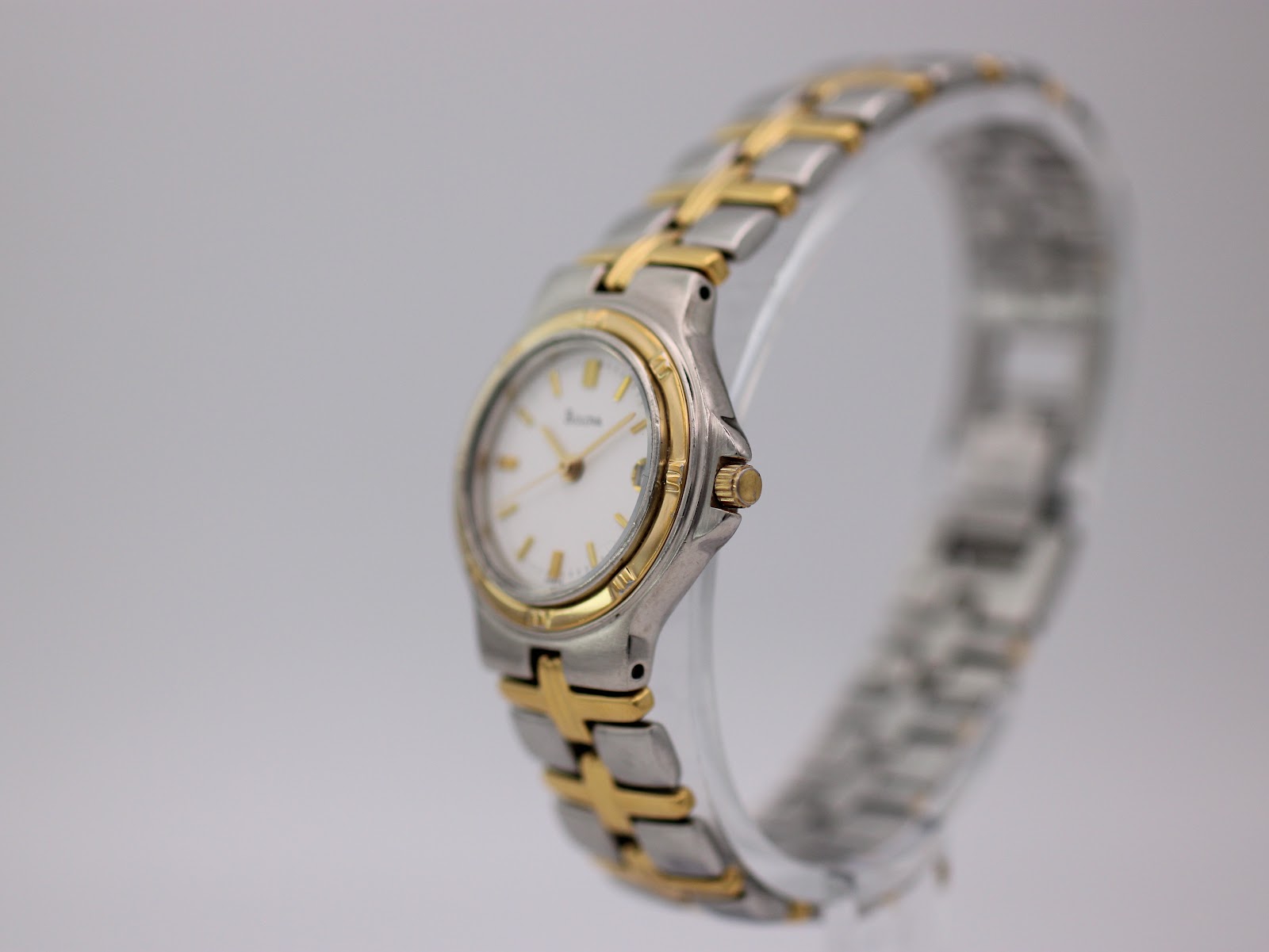 Angled side view of the Bulova two-tone watch on a display stand, showing the case profile and integrated bracelet.