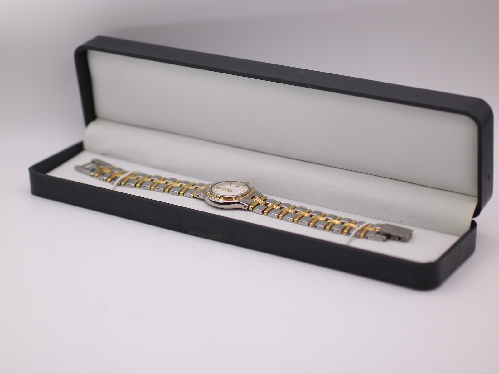 The Bulova two-tone watch displayed open in a generic black presentation box.