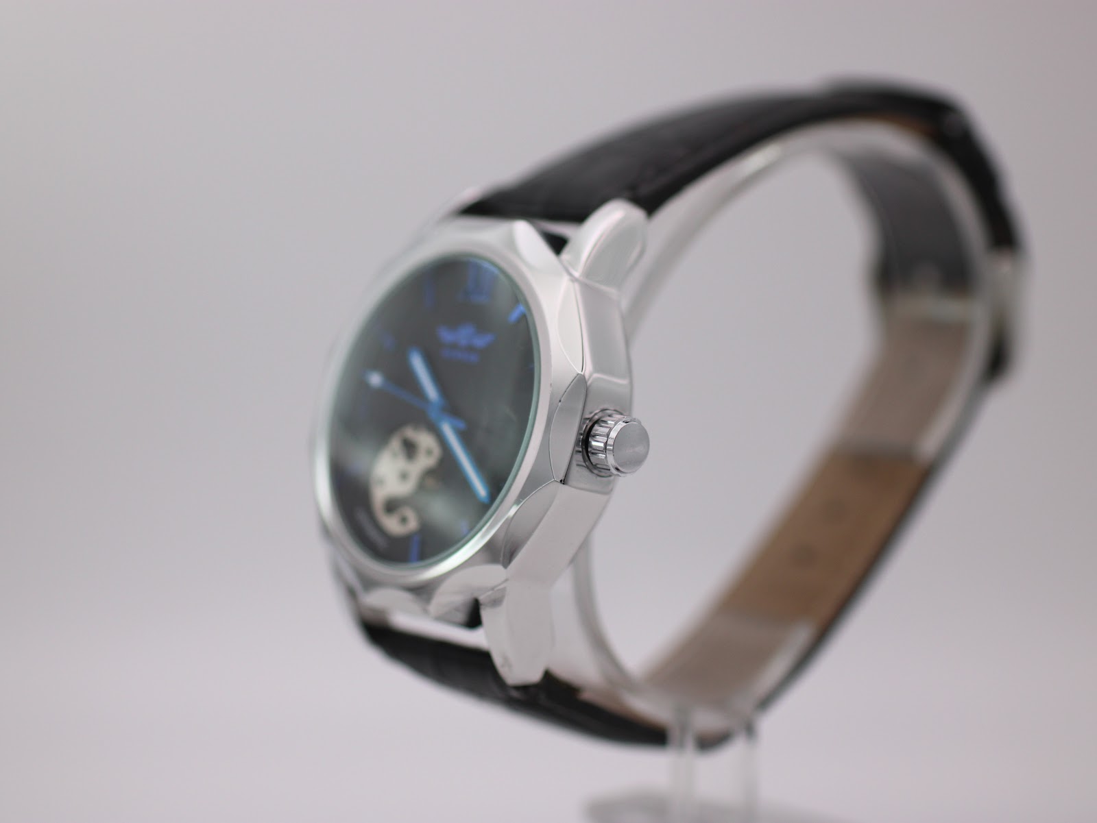 Side view of Winner H199M watch showing the crown and polished silver-tone octagonal case.