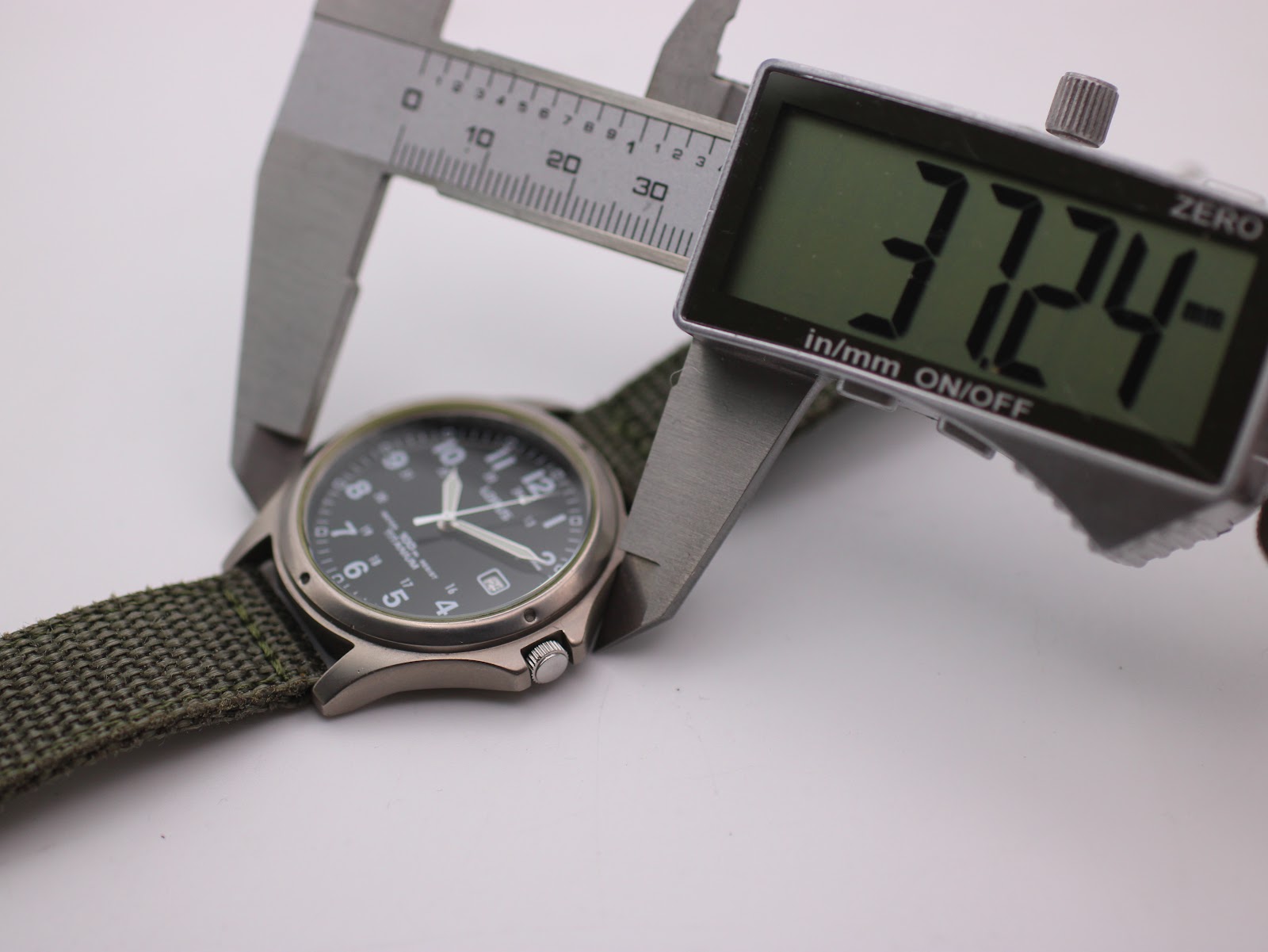 Digital caliper measuring the case diameter of the Lorus watch, showing 37.24mm on the display.