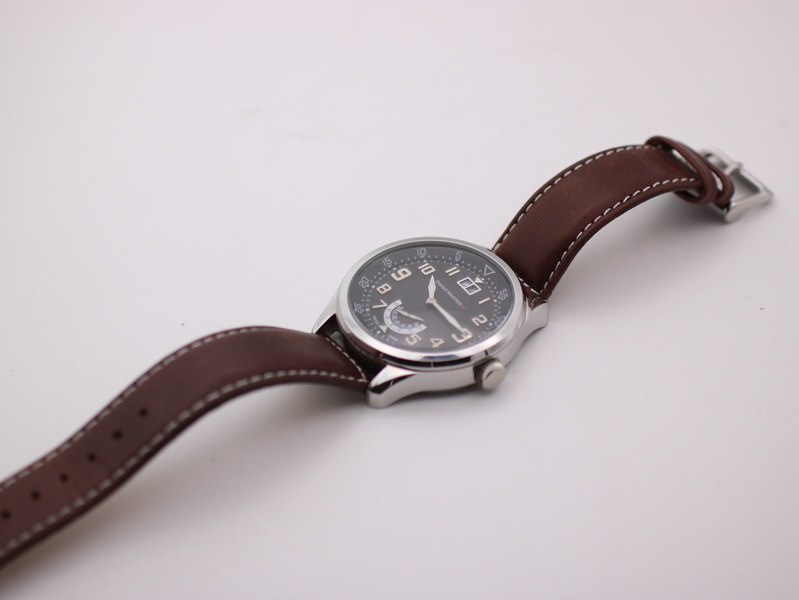Overhead shot of the Swiss Master WB119154 watch with the brown leather strap laid flat.