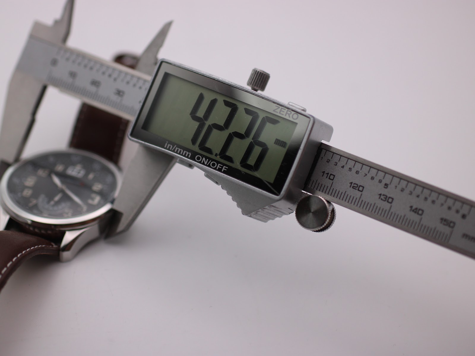 Digital caliper measuring the watch case diameter, showing a reading of 42.26mm.