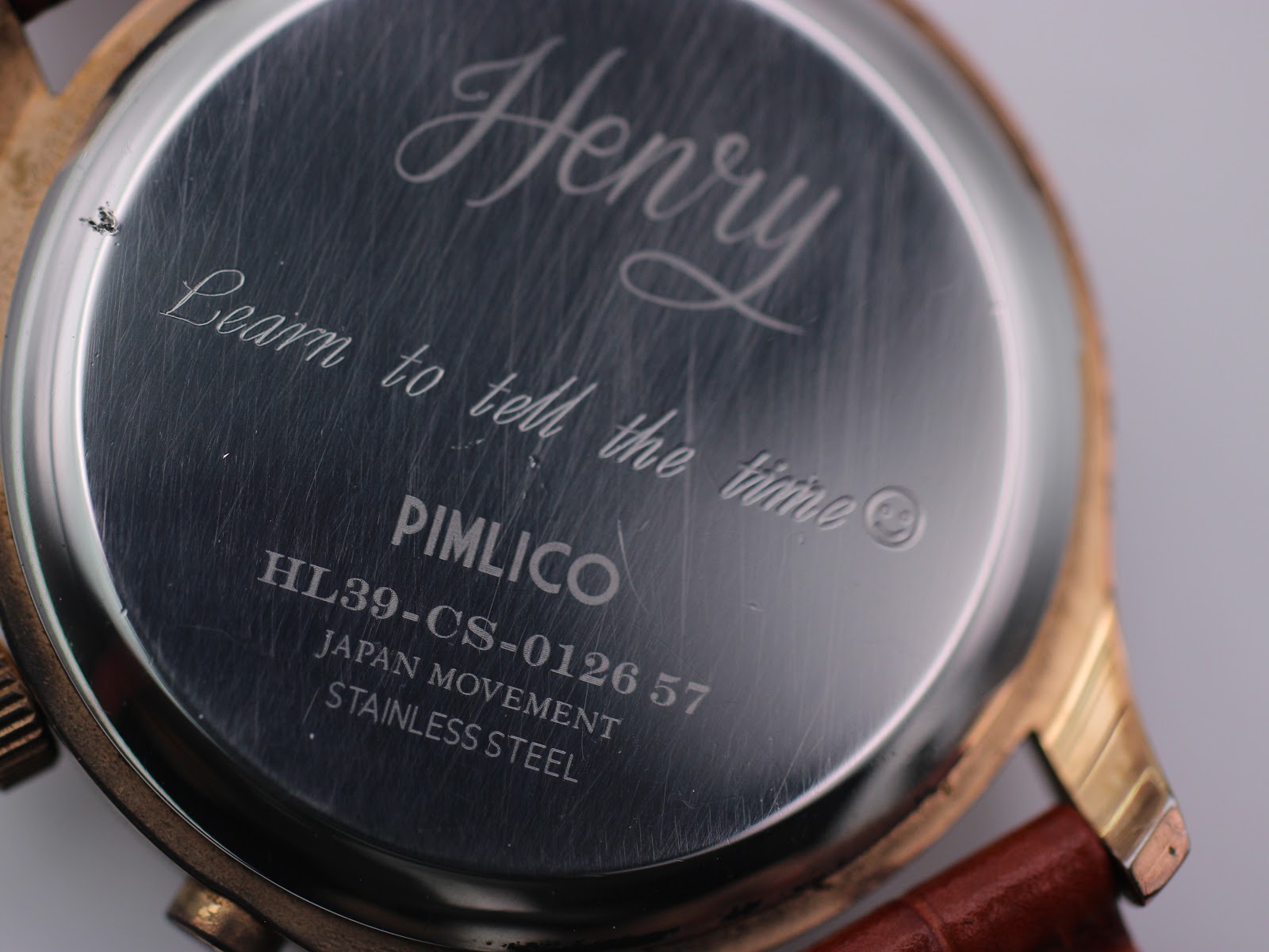 Close-up of the stainless steel case back of the Henry London watch, showing 'PIMLICO', 'HL39-CS-0126 57', 'JAPAN MOVEMENT', and 'STAINLESS STEEL' engravings.