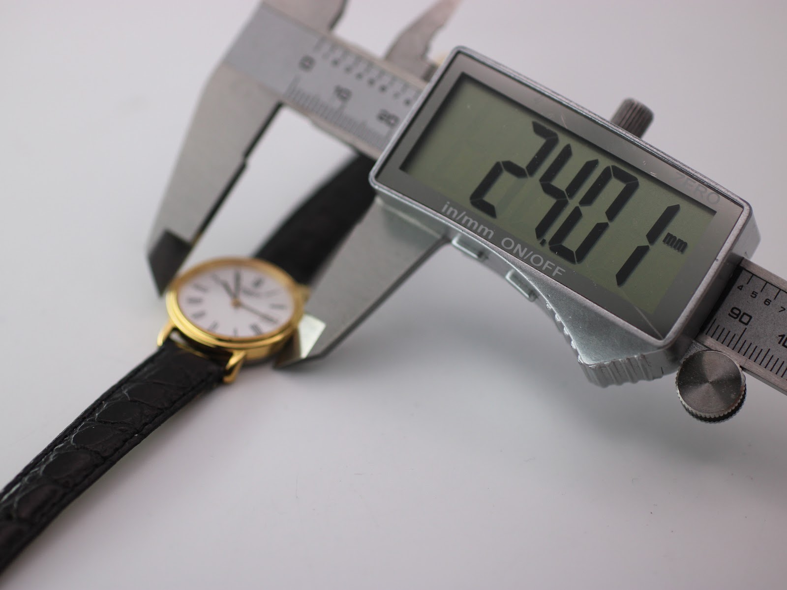 Digital caliper measuring the case diameter of the Tissot watch at 24.07mm.