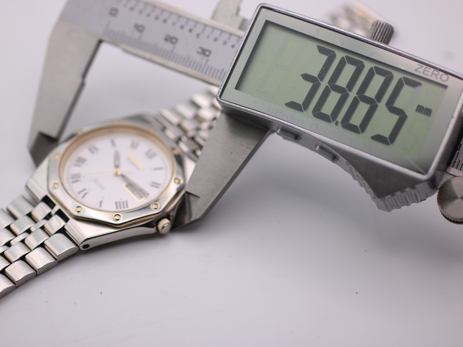 Digital caliper measuring the Seiko SQ 100 case diameter, showing 38.85mm on the display.