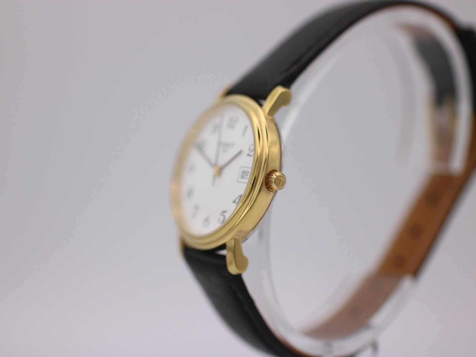 Side view of the Tissot watch showing the gold tone case and crown with Tissot "T" logo.