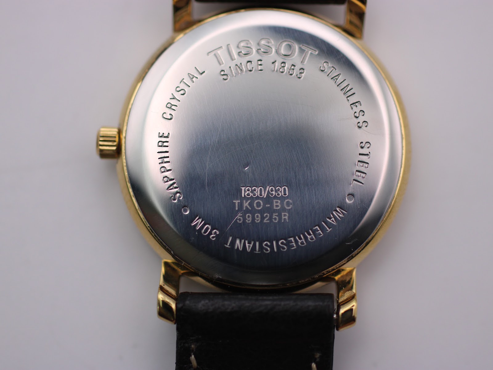 Close-up of the stainless steel case back, engraved with Tissot logo, "Since 1853", "Sapphire Crystal", "Stainless Steel", "30M Waterresistant", model number T830/930, and serial number 59925R.