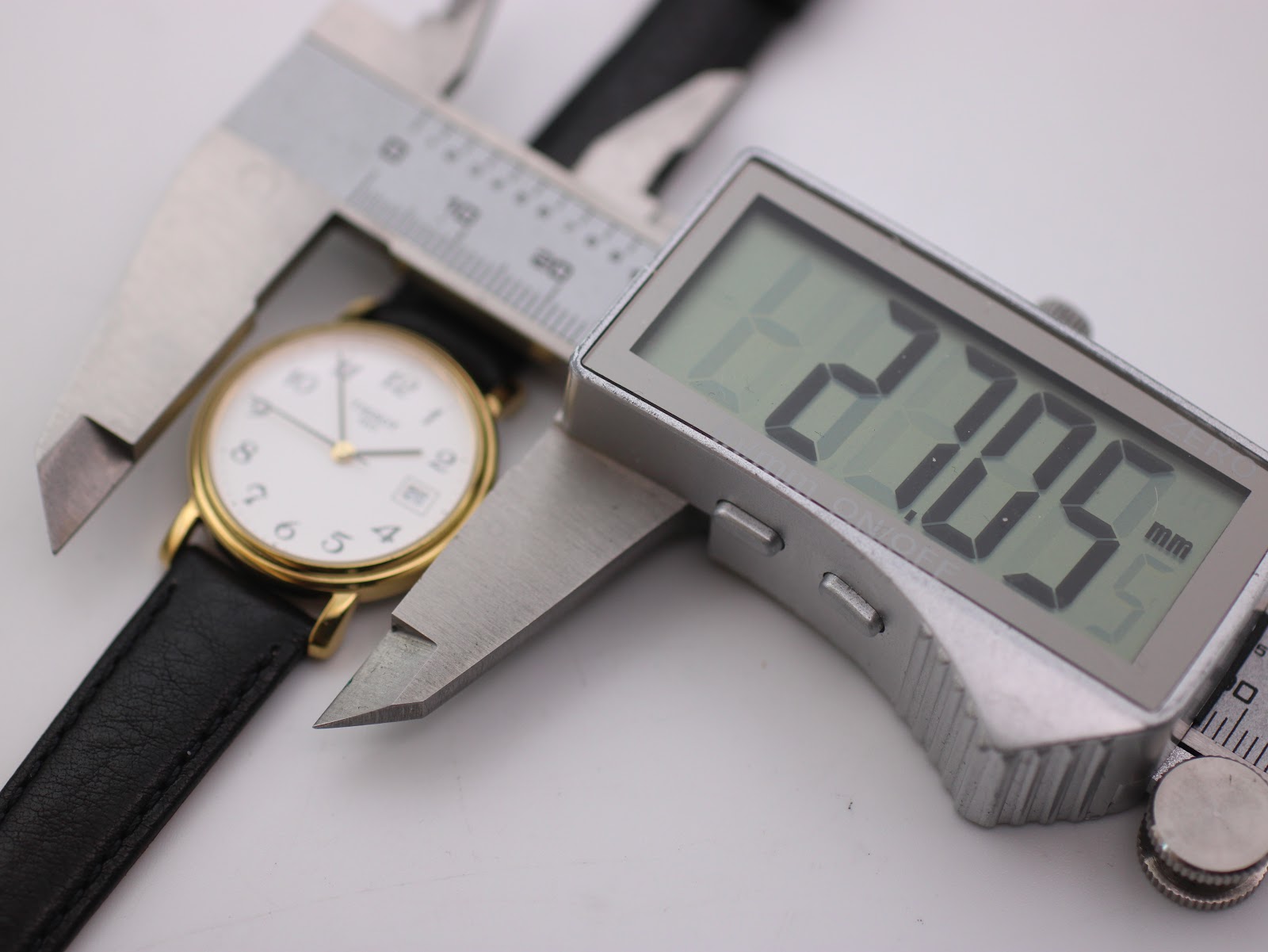 Digital caliper measuring the case diameter of the Tissot watch, displaying 27.05 mm.