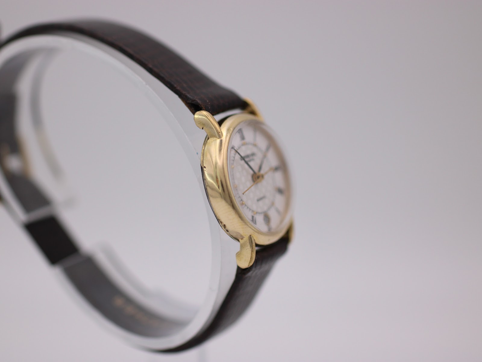 Opposite angled side view of the watch on a display stand, highlighting the lug design.