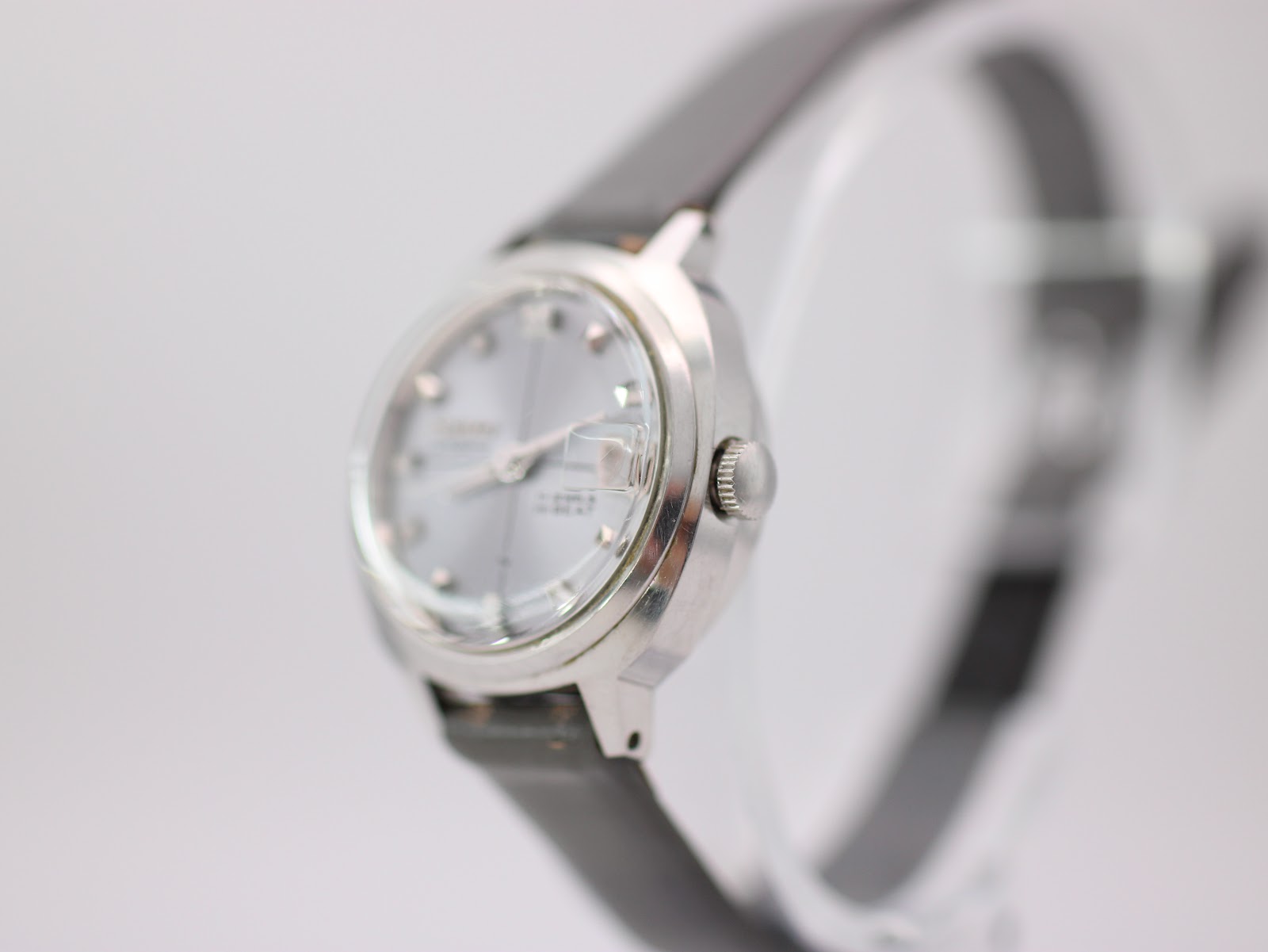 Close-up, face-on view of the Seiko automatic watch dial, detailing the 'SEIKO AUTOMATIC' and '17 JEWELS HI-BEAT' text, pyramid indices, and red-numbered date window.