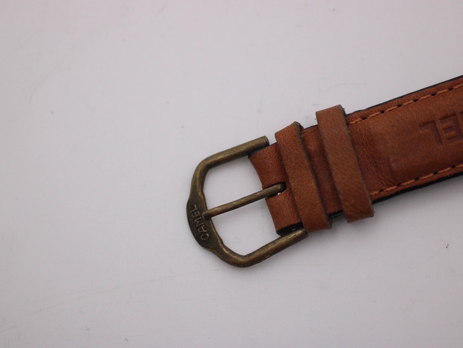 Detailed shot of the bronze-tone pin buckle, clearly engraved with the 'CAMEL' brand name.