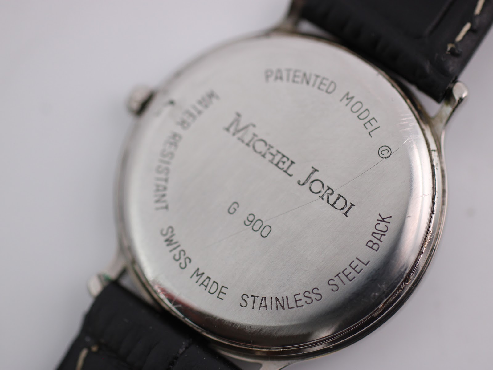 Detailed close-up of the watch case back engravings for Michel Jordi G 900.