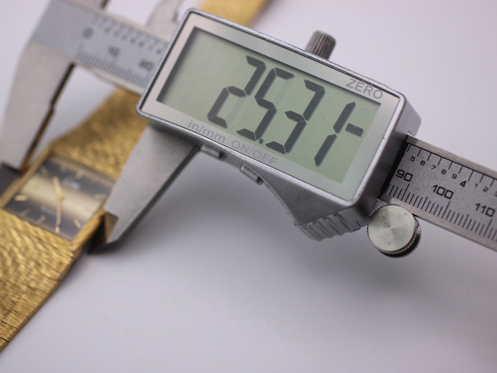 Macro shot of the Swiss Ronda quartz movement inside the watch, showing '1 jewel unadjusted'.