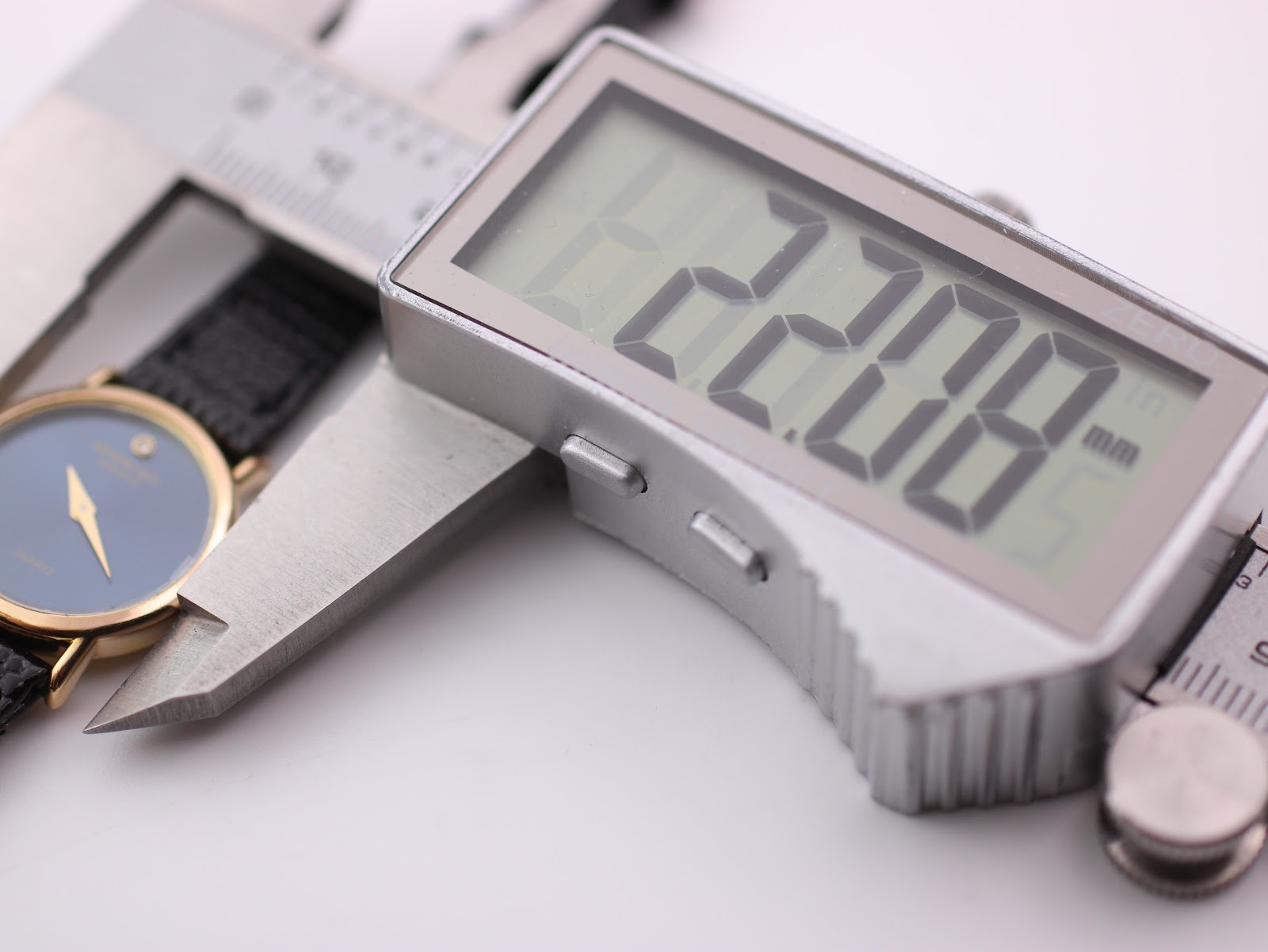 Digital caliper measuring the Raymond Weil watch case diameter, showing a precise reading of 22.08mm.