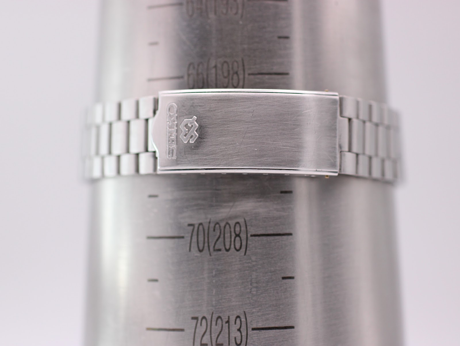 Close-up of the Seiko watch steel bracelet clasp on a wrist sizing gauge, showing a wrist circumference of 198mm.