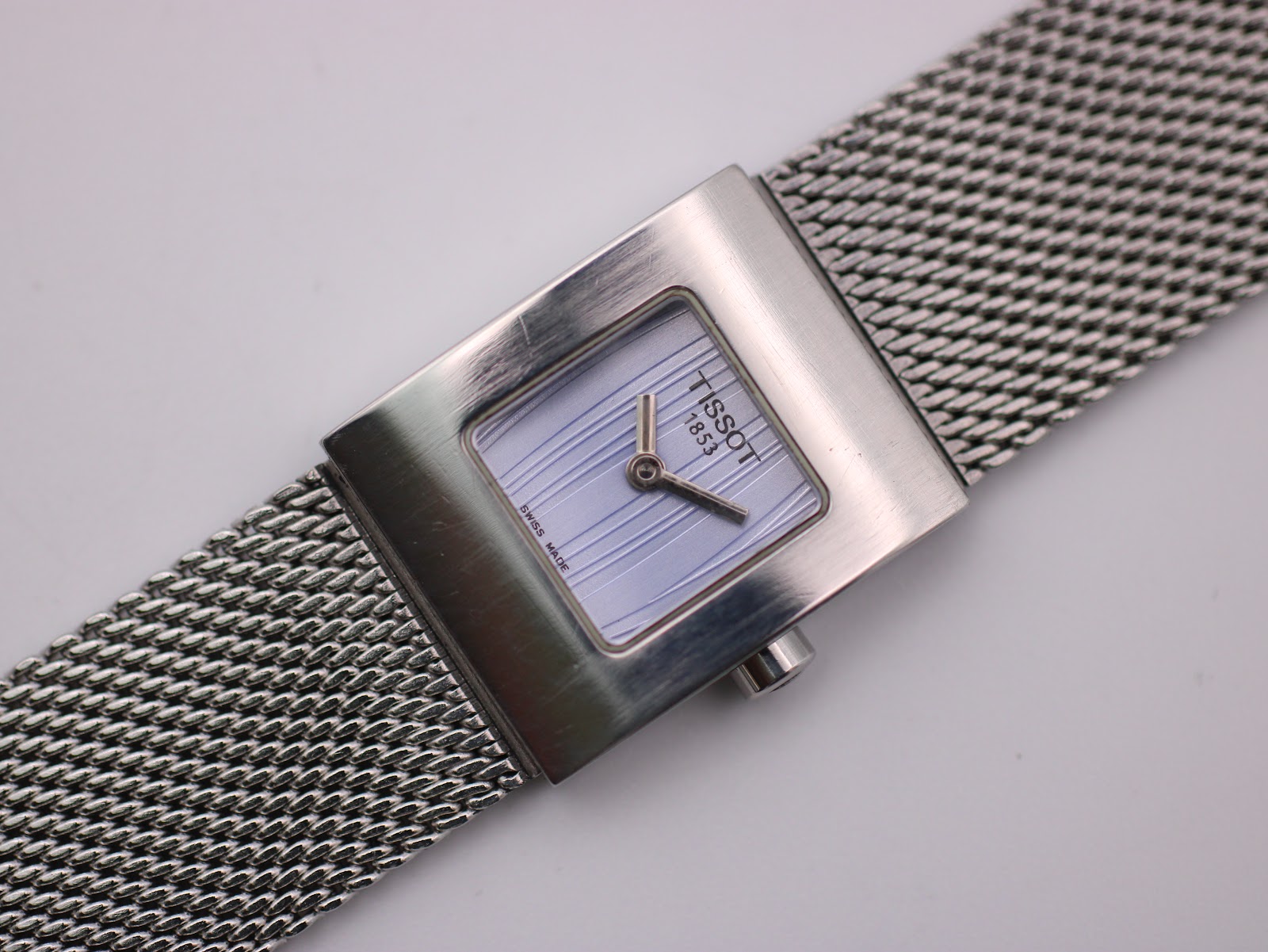 Close-up, angled view of the Tissot L610K dial, showing the 'TISSOT 1853' logo, 'SWISS MADE' text, and vertical dial texture.