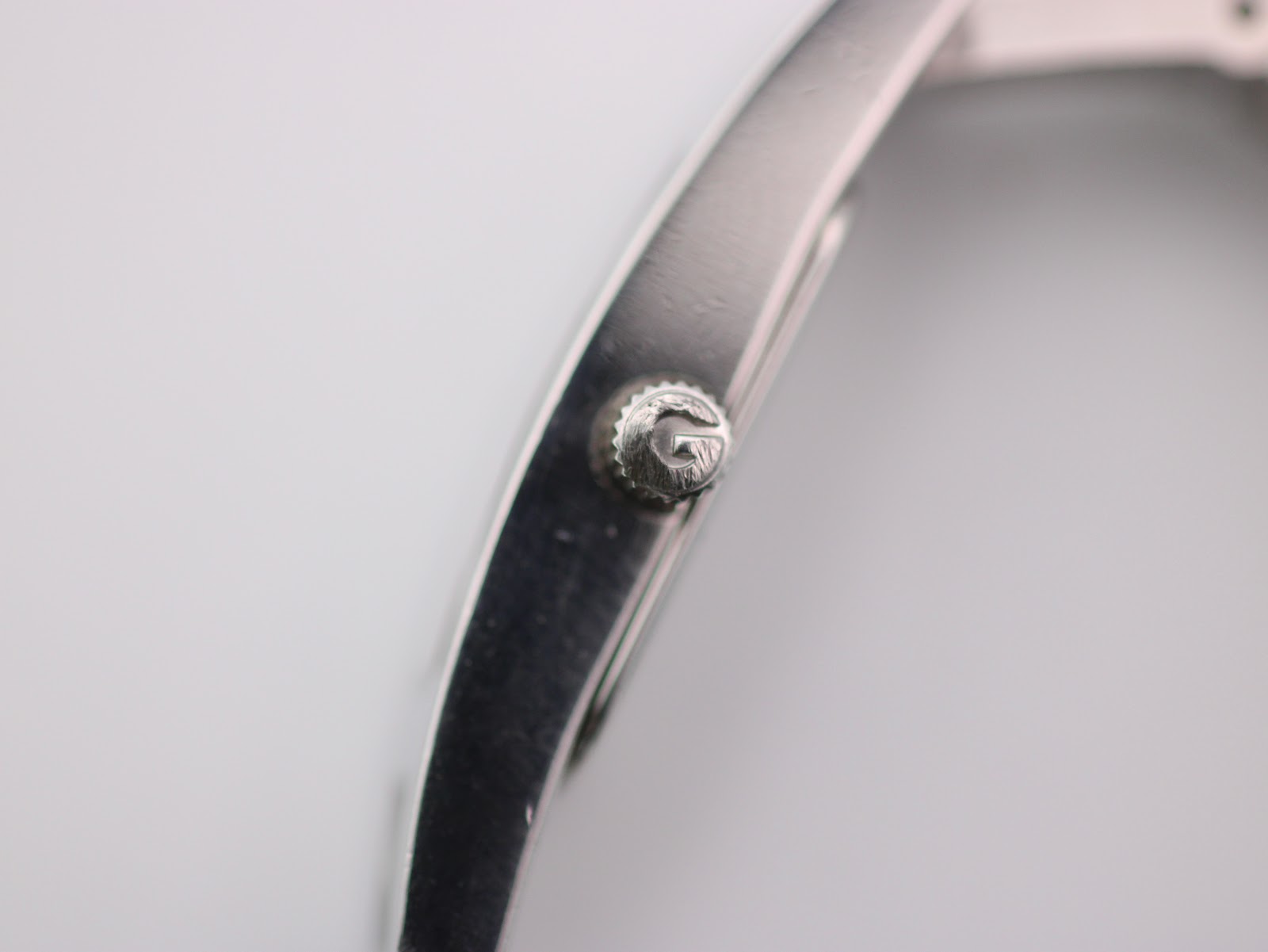 Close-up of the Gucci 3900 L crown, clearly showing the embossed 'G' logo.