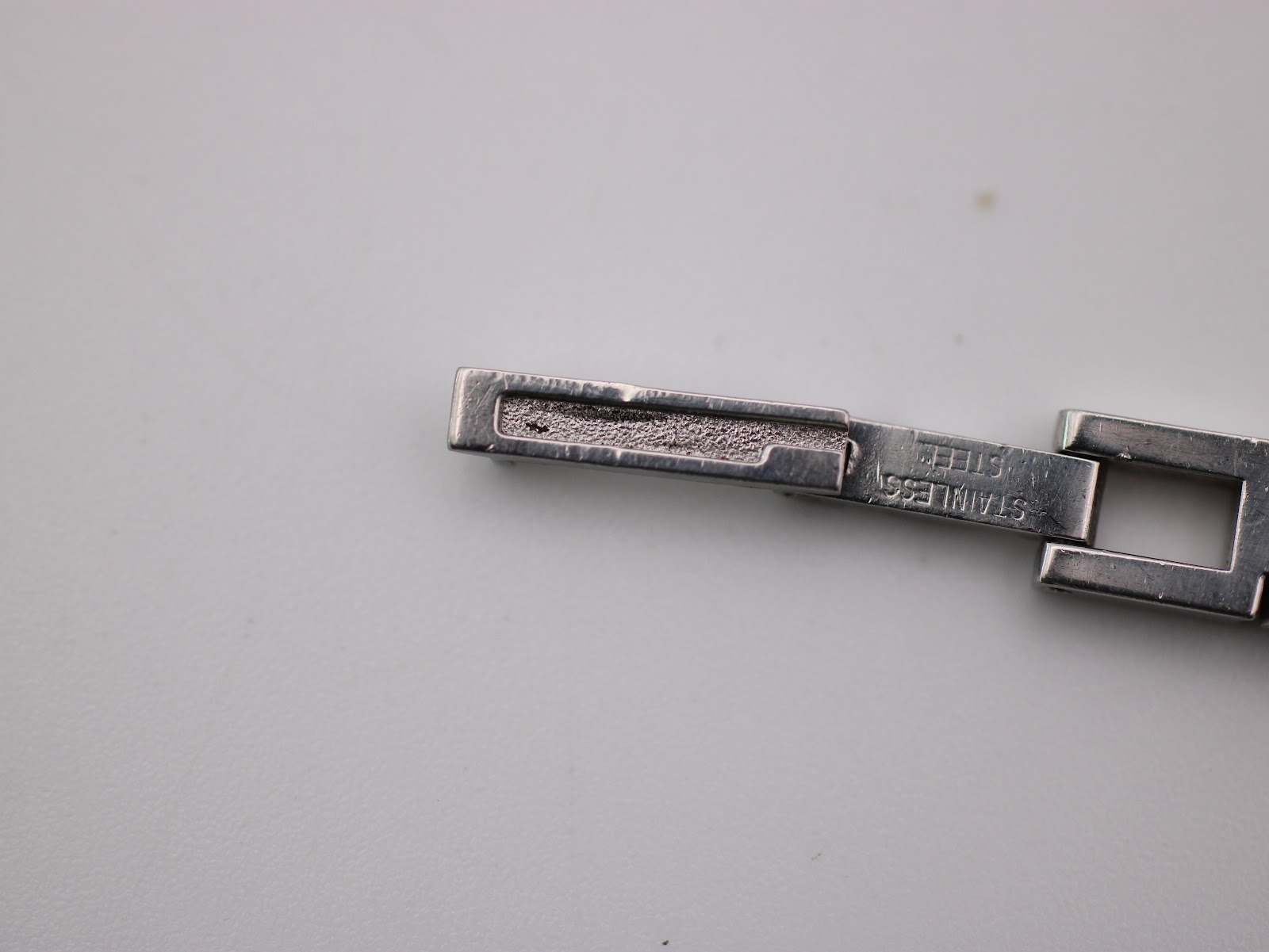 Close-up of the Gucci 3900 L bracelet's hidden clasp, with 'STAINLESS STEEL' engraved inside.
