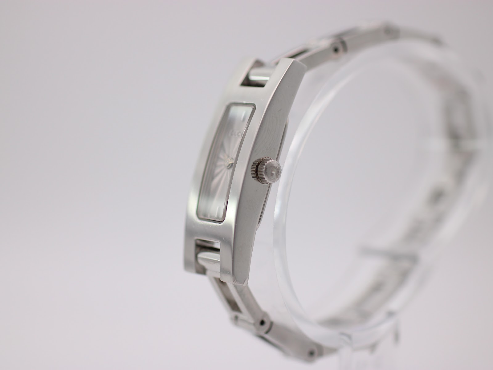Side profile view of the Gucci 3900 L watch, showing the signed crown with a 'G' logo and the brushed case finish.