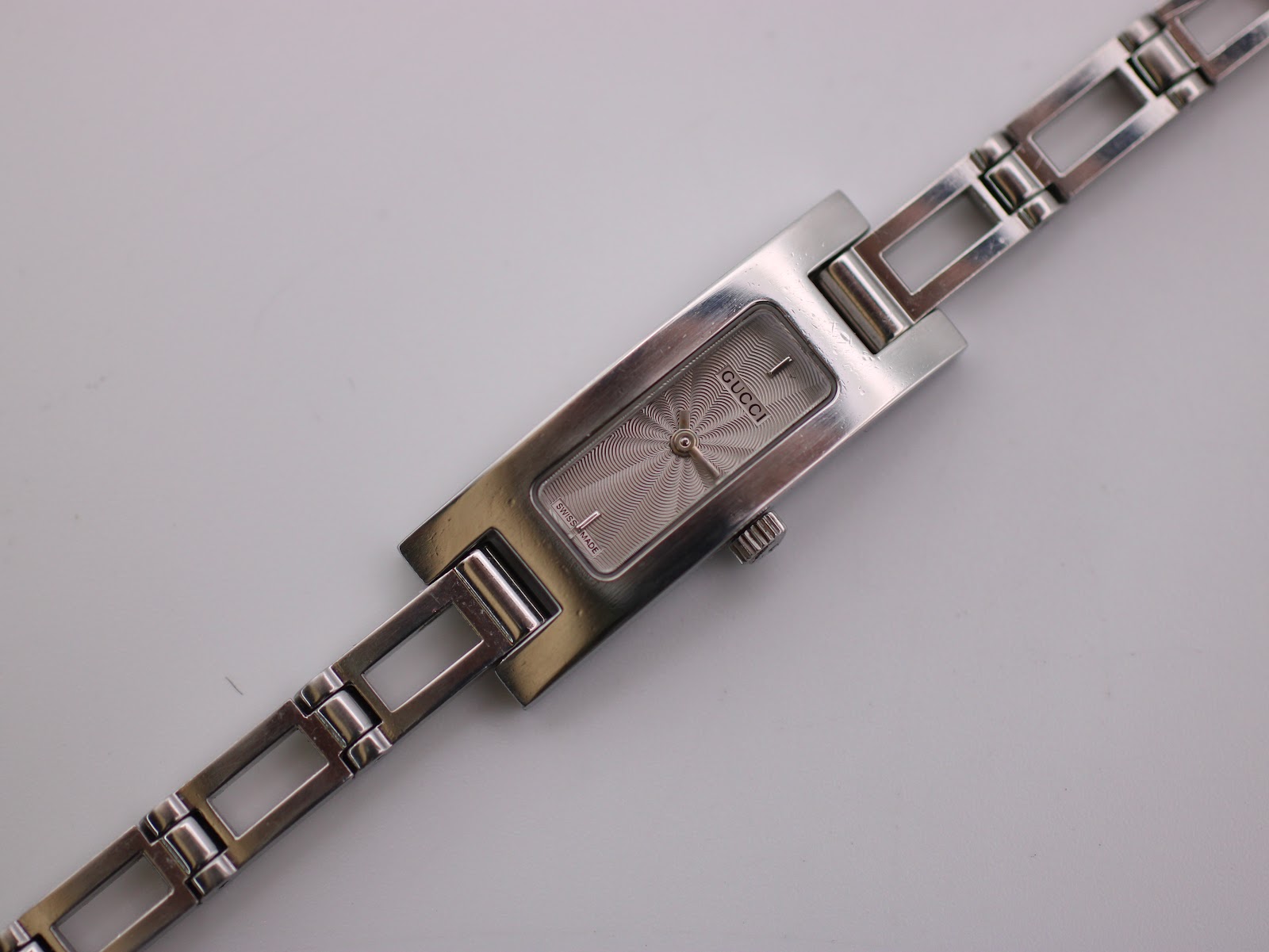 Close-up, top-down view of the Gucci 3900 L watch dial and the upper part of the integrated bracelet.