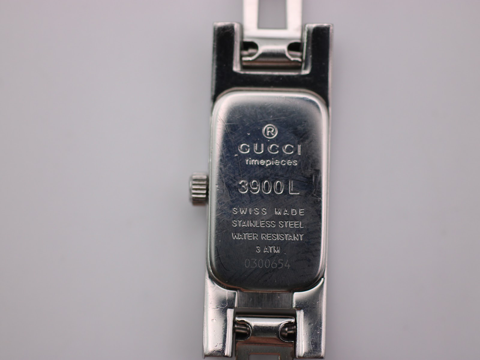 Detailed close-up of the Gucci 3900 L case back engraving, showing brand, model, serial number '0300654', and 'WATER RESISTANT 3 ATM'.