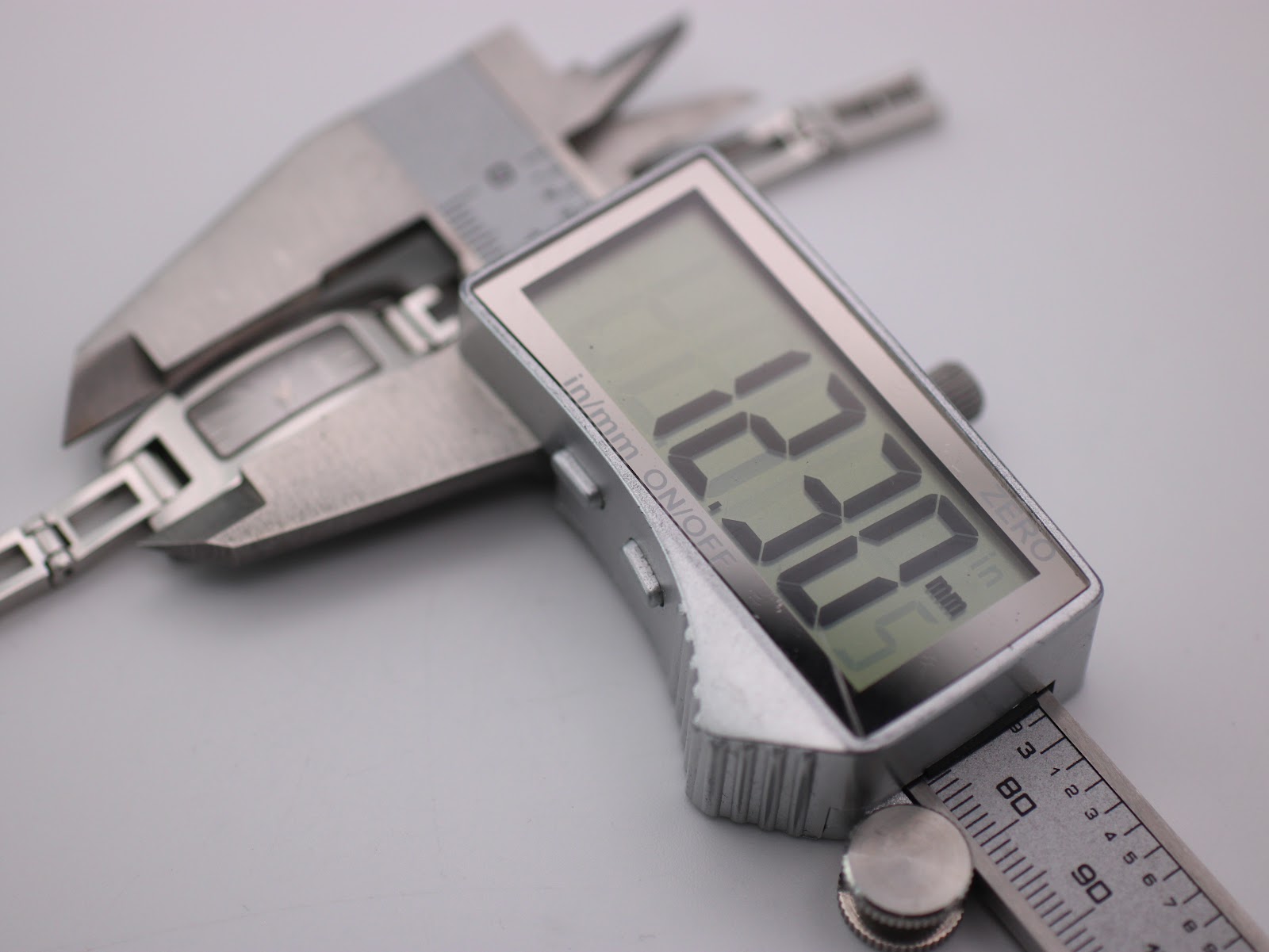 Digital caliper measuring the Gucci 3900 L case diameter, displaying an exact measurement of 12.22 mm.