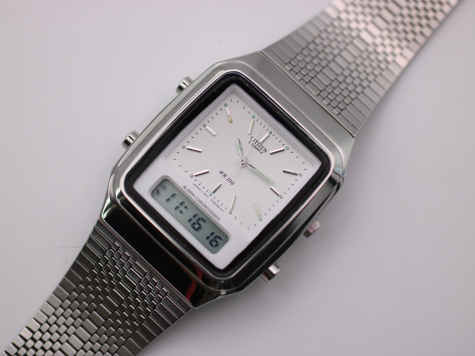 Angled close-up of the Citizen C480 dial, showing the analogue hands, digital display, and "WR 100" text.