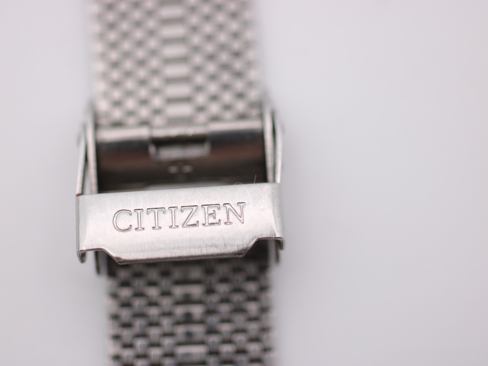 Close-up of the polished stainless steel fold-over clasp, clearly showing the "CITIZEN" signature engraving.