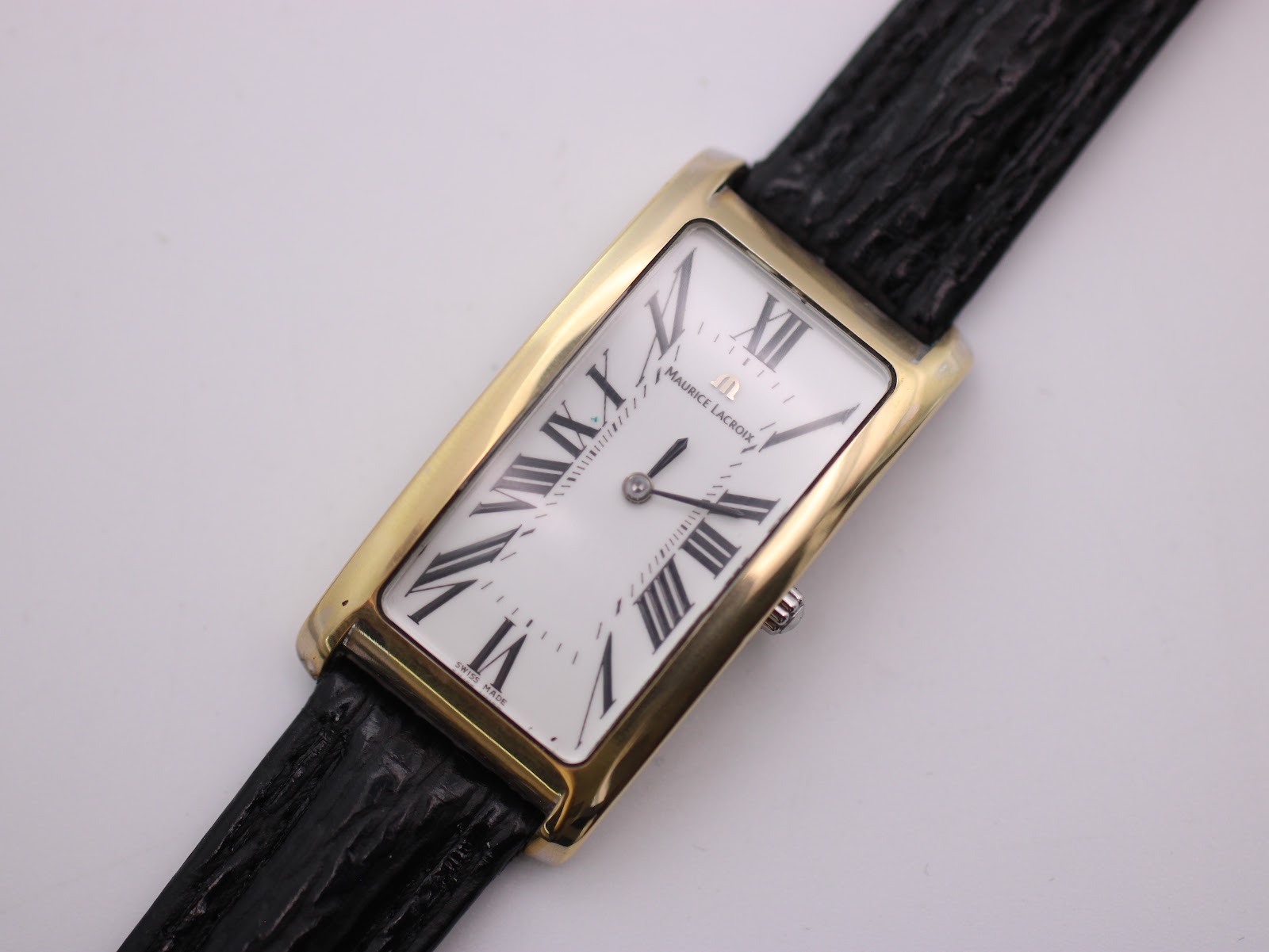 Top-down close-up of the Maurice Lacroix watch dial, showing brand logo, Roman numerals, and "Swiss Made" at 6 o'clock.
