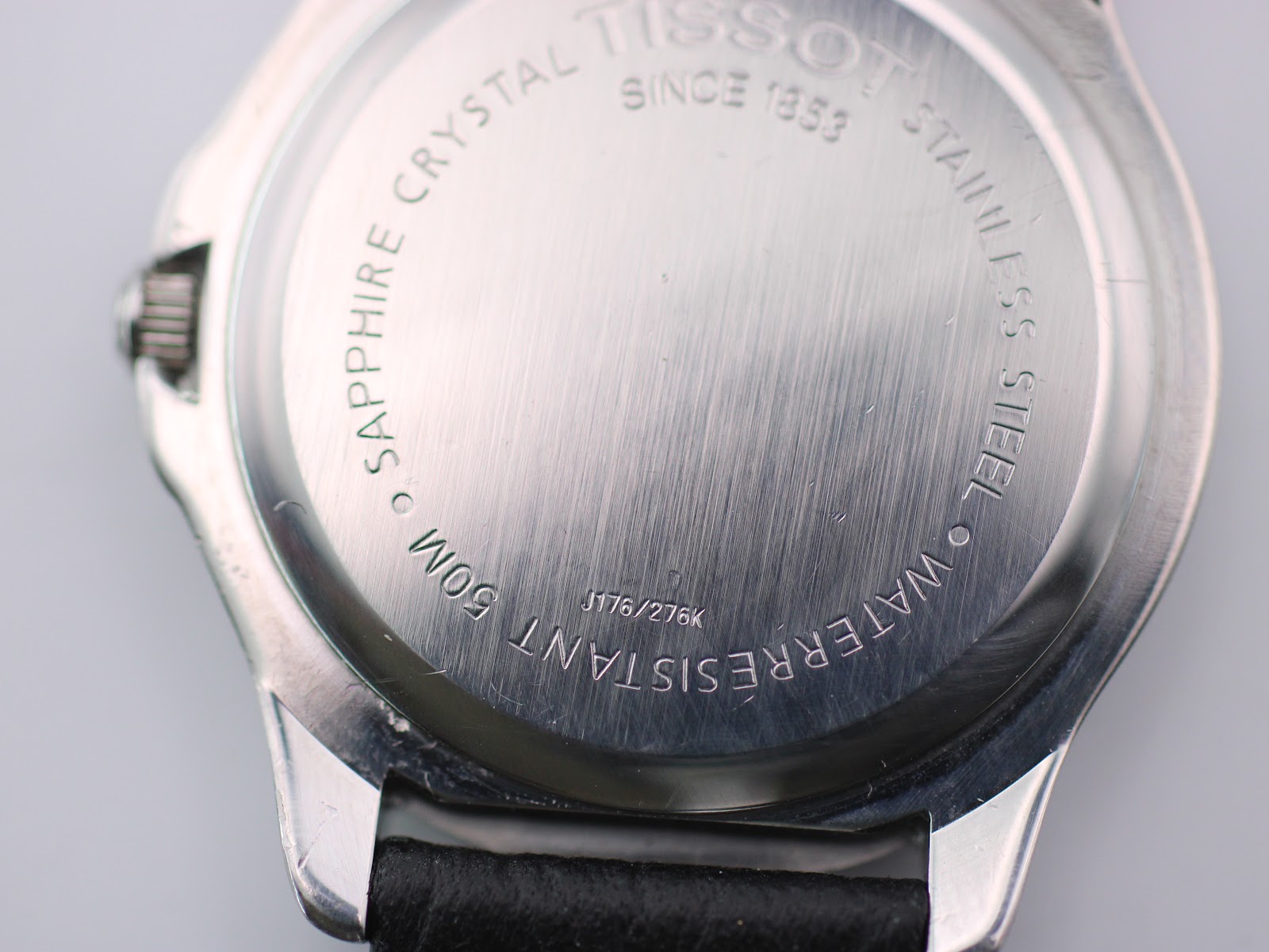 Close-up of the Tissot PR 50 case back, showing serial number J176/276K, 'Sapphire Crystal', 'Waterresistant 50m', and 'Stainless Steel' engravings.