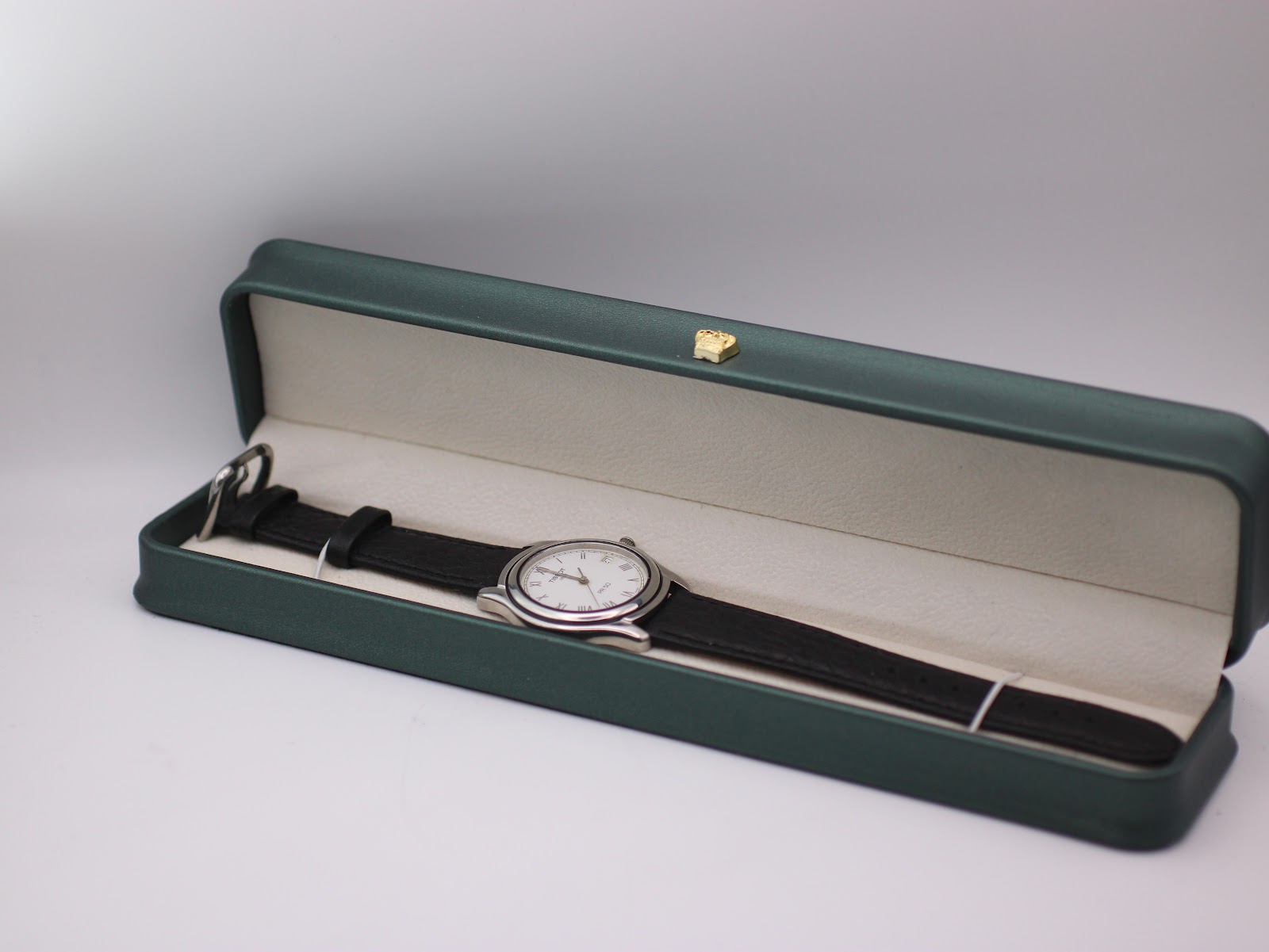 Tissot PR 50 watch with black leather strap displayed in a green presentation box.