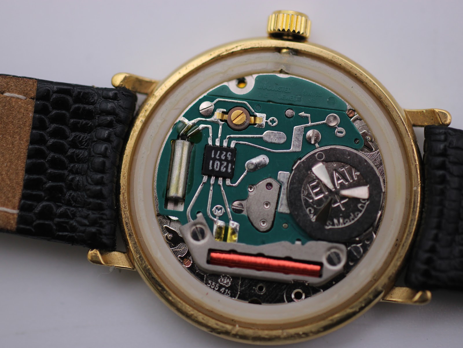 Close-up of the watch interior showing the Swiss quartz movement, battery, and case structure.