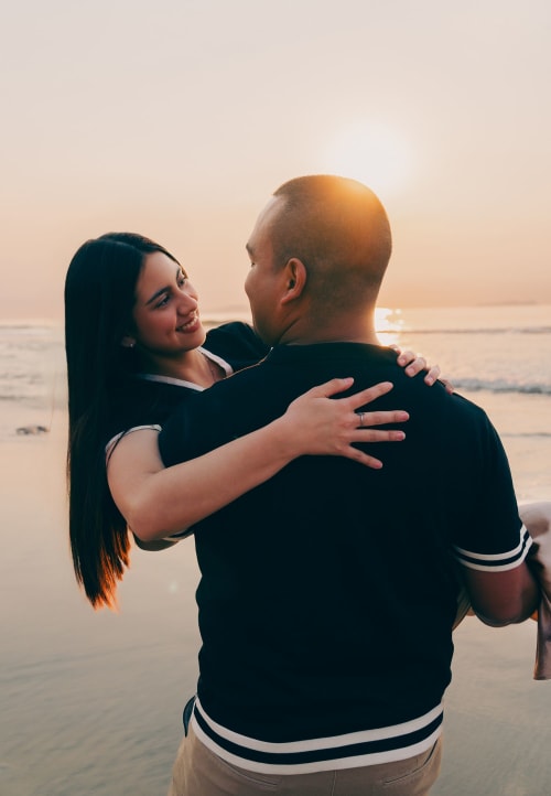 Novio cargando a novia en playas de Tijuana