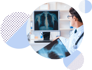 Doctor looking away at a screen showing a chest x-ray.