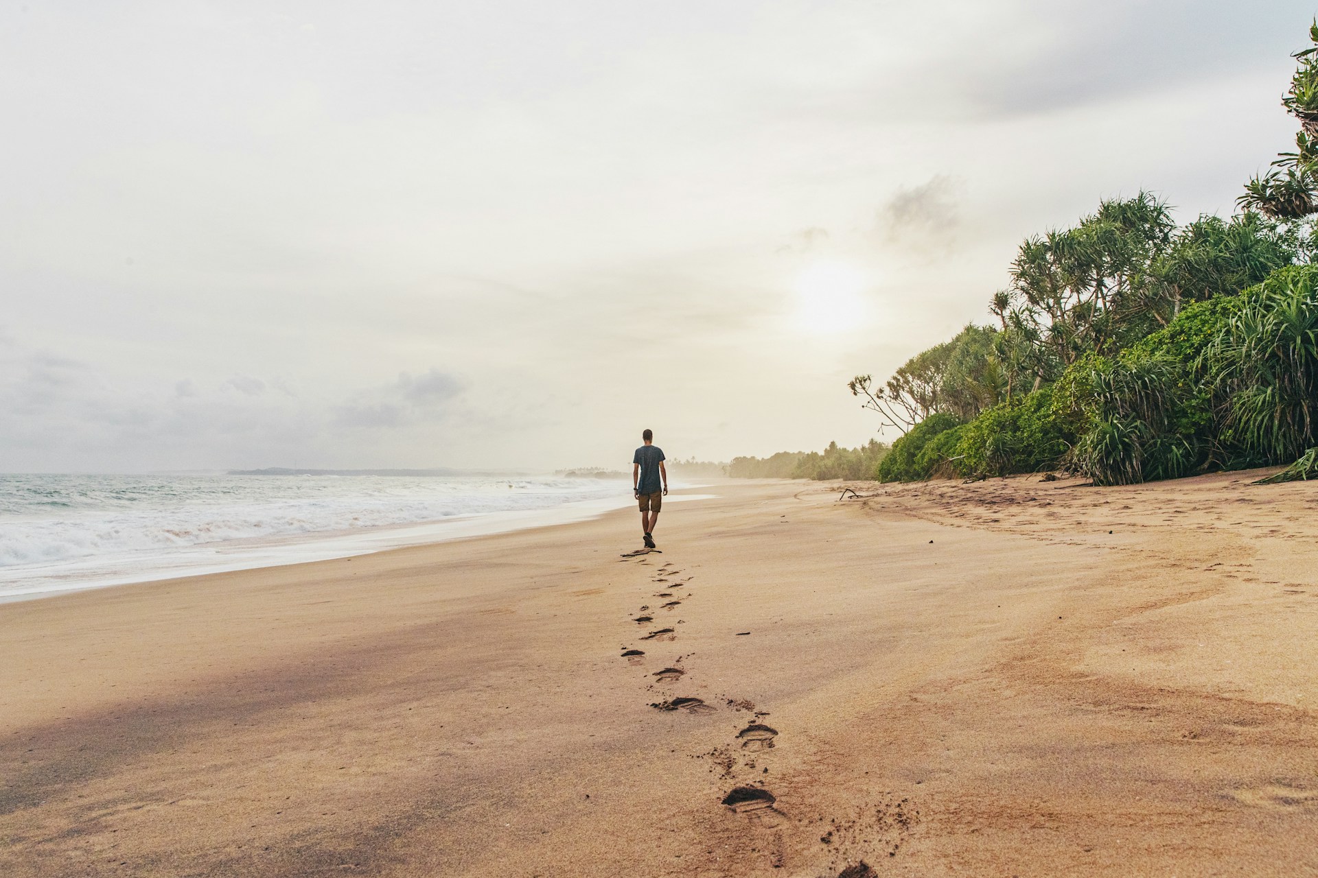 Man walking along deserted beach