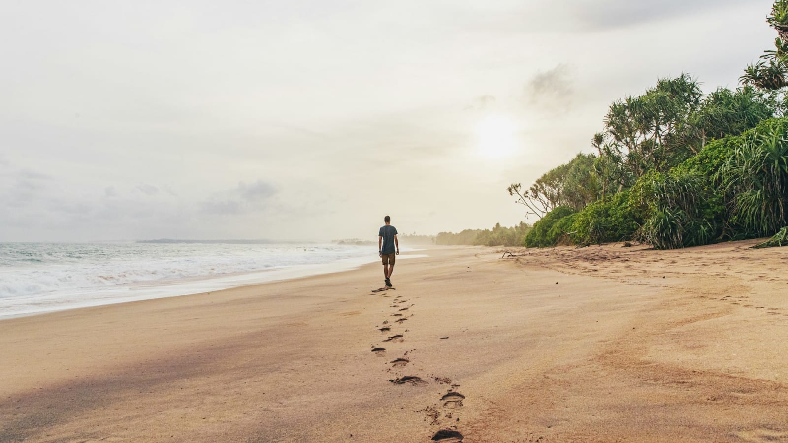 Man walking along deserted beach