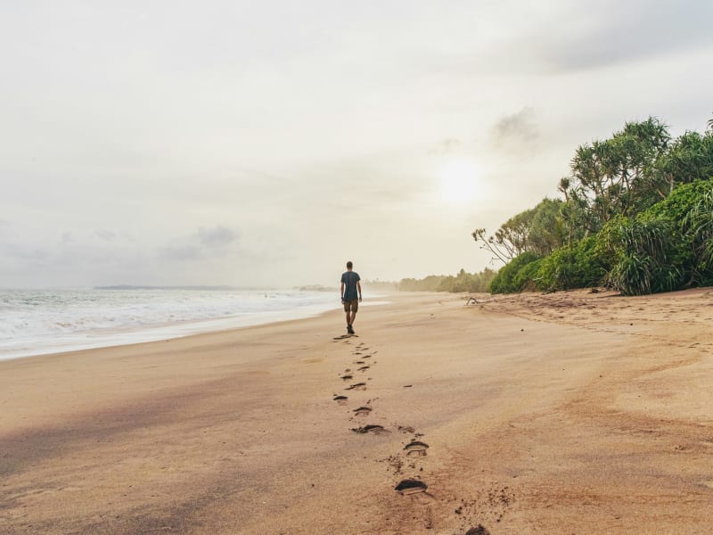 Man walking along deserted beach