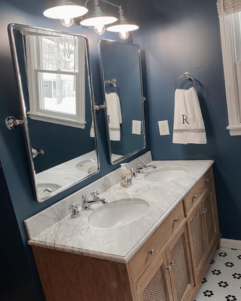Double vanity with marble counter and navy walls after the remodel