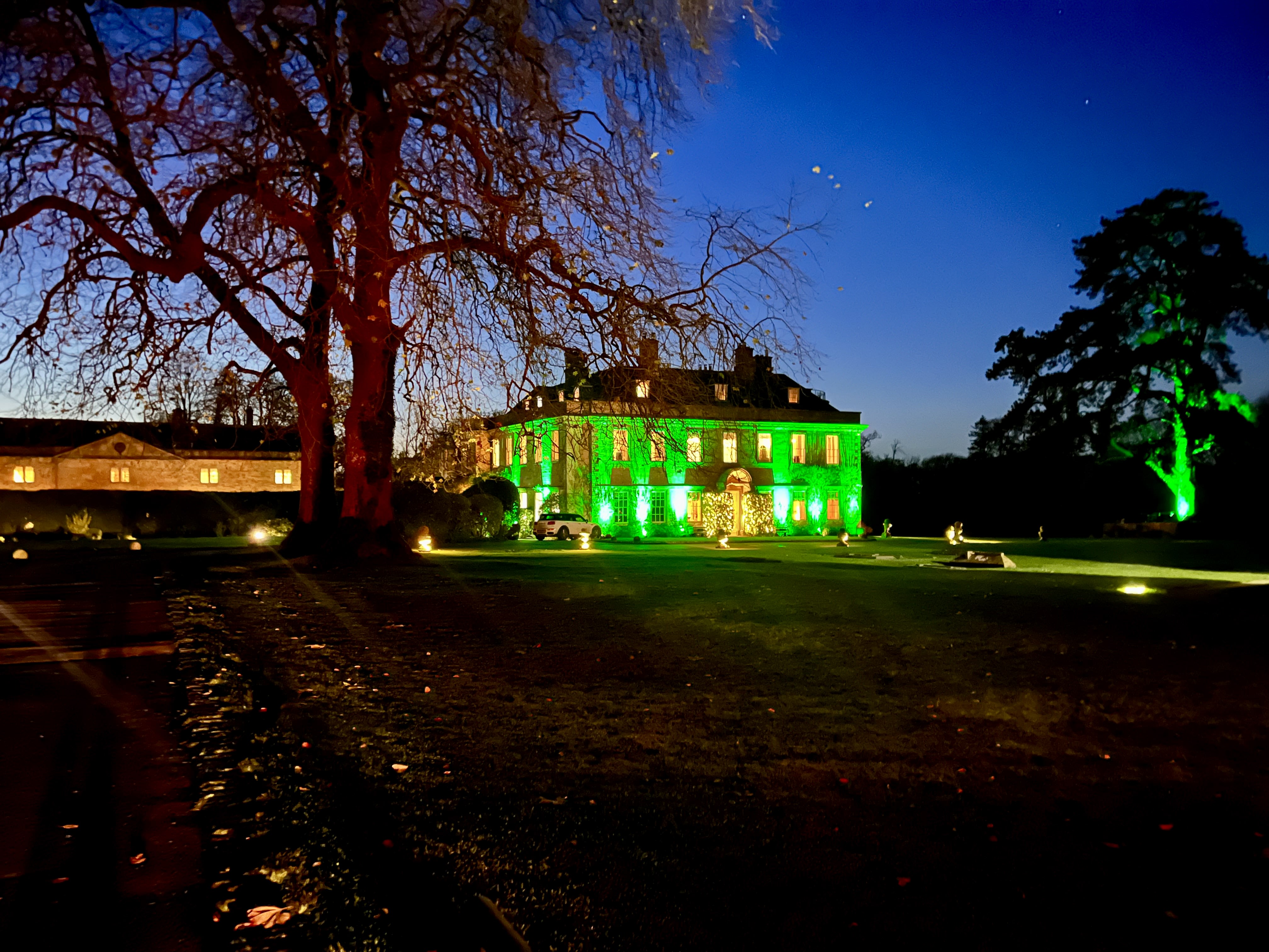 Babington House wedding venue exterior with green LED mood lighting, luxury wedding lighting design in Somerset