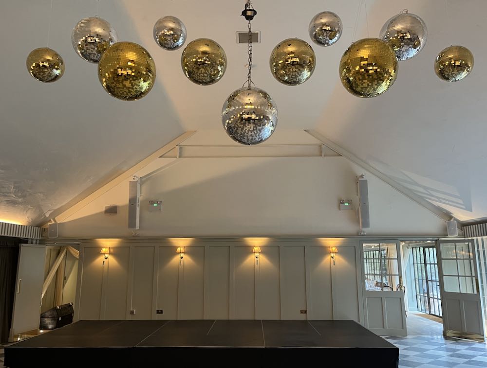 Professional party planning and event organization at Kin House with elegant mirrorball clusters and sophisticated lighting