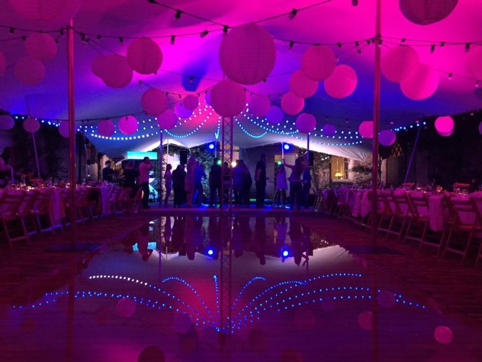 Stretch marquee with professional lighting design and festoon lights creating a warm evening atmosphere
