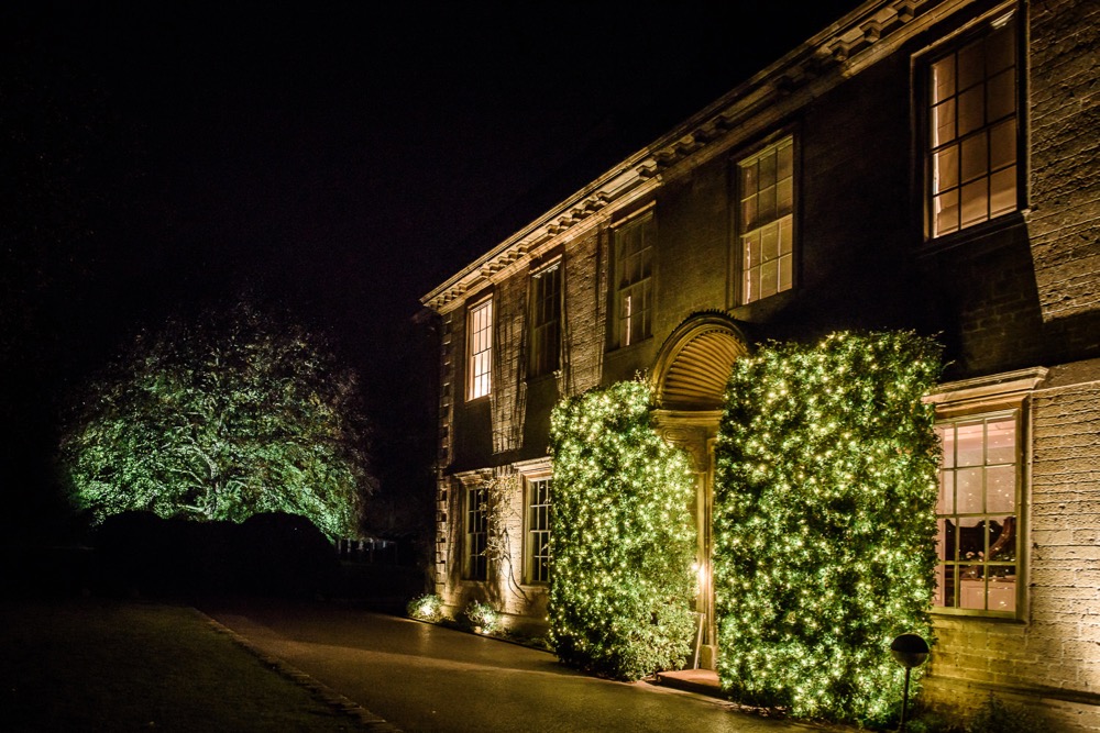 Babington House front of house wedding celebration with fairy light bushes