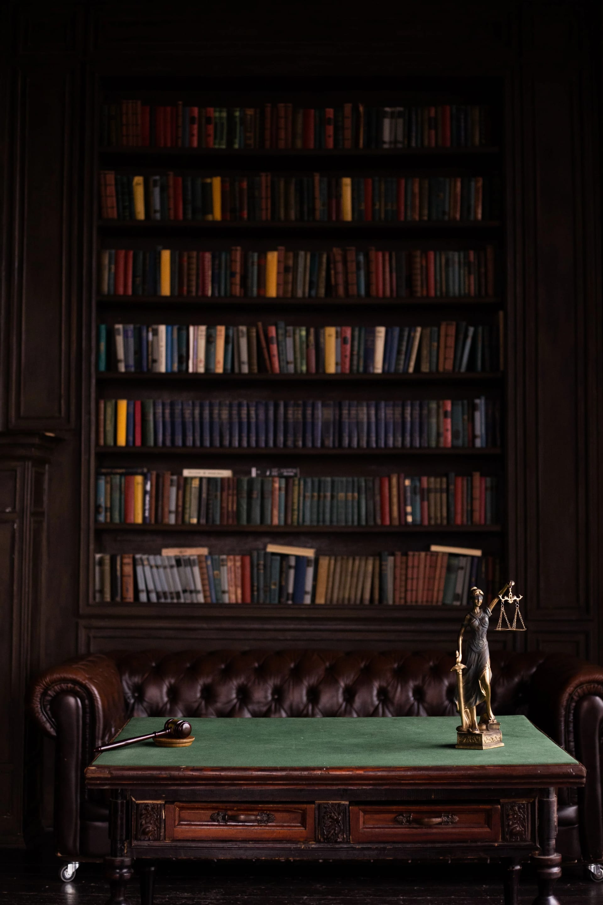 Bibliothèque juridique avec ouvrages anciens, maillet et statue de la Justice