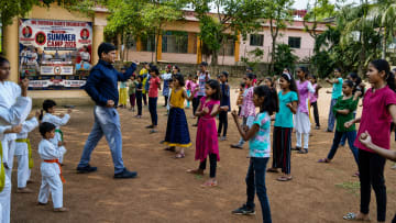 Two students practicing realistic self-defense drills in safety gear