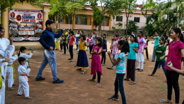 Two students practicing realistic self-defense drills in safety gear