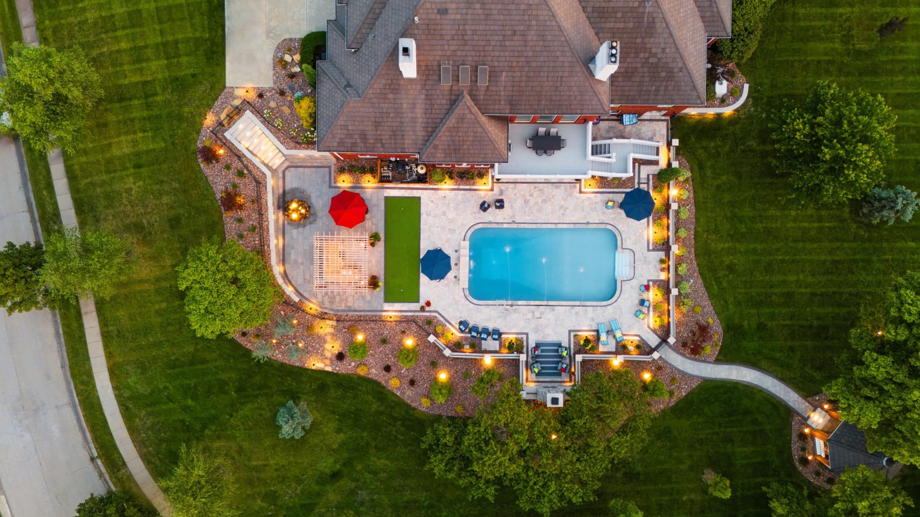 Kansas City, MO travertine patio, pergola, pool, and outdoor kitchen build by Kansas City Hardscapes